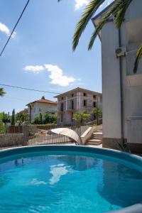 a blue swimming pool in front of a building at Villa Lili in Lovran