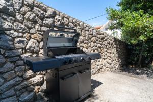 a barbecue grill sitting on top of a stone wall at Villa Lili in Lovran