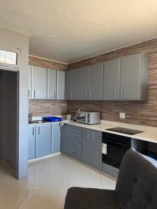 a kitchen with white cabinets and a stove top oven at Afsaal 612 in Amanzimtoti
