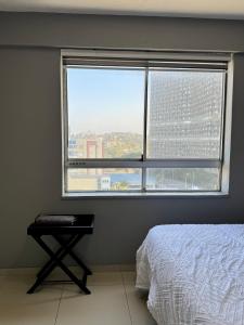 a bedroom with a bed and a large window at Afsaal 612 in Amanzimtoti