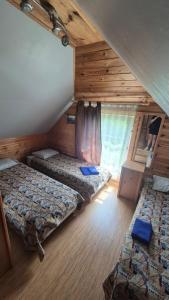 a room with three beds and a window in a house at Kupiškio marių vila in Aukštupėnai