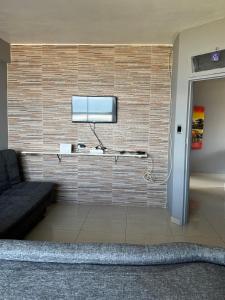a living room with a tv on a brick wall at Afsaal 612 in Amanzimtoti