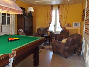 a billiard room with a pool table and chairs at La Bruyère-Maison d'hôtes-Piscine in May-sur-Orne