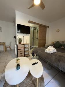 a living room with a bed and two white tables at Saint-Pierre Studio in Avignon