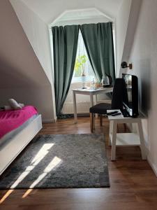 a bedroom with a bed and a desk and a window at Mendoza Steakhaus & Hotel in Mirow
