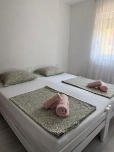 two beds with pink towels on top of them at Apartment Lunette in Mostar