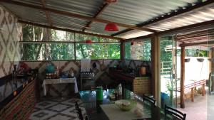 a kitchen with a table in a room with windows at Pousada Recanto Dos Pássaros in Colégio
