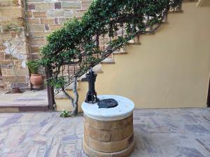 a water fountain in a barrel next to a staircase at Arhodico Simou mansion in Kambos +42 photos