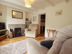 a living room with a couch and a fireplace at Vis Valley View in Pentewan