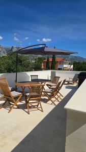a table and chairs with an umbrella on a patio at Studios Ilic in Seline