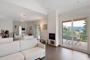 a living room with a white couch and a balcony at Villa Capo Berta View in Diano Marina