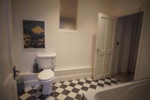 a bathroom with a toilet and a sink and a tub at Garden Seafront Flat Hastings in Hastings