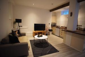 a living room with a couch and a table at Garden Seafront Flat Hastings in Hastings +4 photos