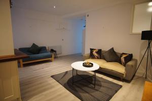 a living room with a couch and a table at Garden Seafront Flat Hastings in Hastings