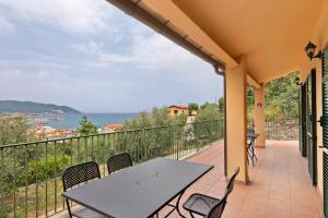 a patio with a table and chairs on a balcony at Villa Capo Berta View in Diano Marina