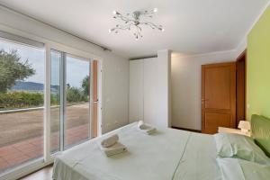 a bedroom with a bed and a large window at Villa Capo Berta View in Diano Marina