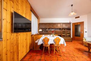 a kitchen with a table with two chairs and a television at Casa Lena in Colorina