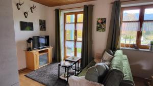 a living room with a couch and a tv at Ferienwohnung Osser Woid in Lohberg