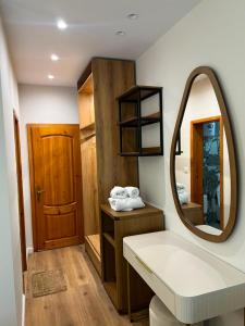 a bathroom with a mirror and a sink at Hotel Restorant Riza in Tirana