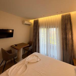 a hotel room with a bed and a table and a window at Hotel Restorant Riza in Tirana