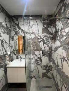 a bathroom with a glass shower and a sink at Hotel Restorant Riza in Tirana