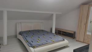 a bedroom with a bed with a blue comforter at Enjoy strudio apartment M in Murfatlar