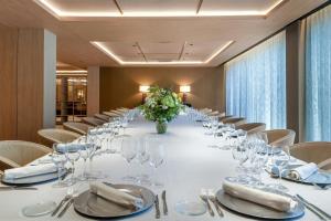 a long table in a room with chairs and glasses at AC Hotel Atocha by Marriott in Madrid