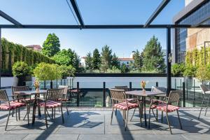 a patio with tables and chairs in a building at AC Hotel Atocha by Marriott in Madrid