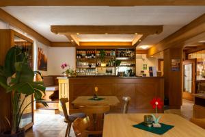 a bar in a restaurant with tables and chairs at Kyrr Smart Mountain Retreat in Moena