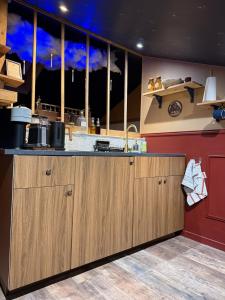 a kitchen with wooden cabinets and a counter top at Le grenier des sorciers in Balbigny