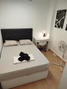 a white bedroom with a bed with a desk and a white bed sidx sidx sidx at Rooms in the center City in Barcelona