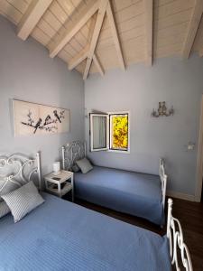 a bedroom with two beds and a window at Flowerhouse in Porto Heli