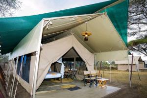 a tent with a table and chairs in it at Royal Horizon Adventure in Sekenani +14 photos