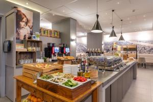 a restaurant with a buffet of food on a counter at Ramada The Hague Scheveningen in Scheveningen