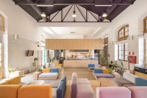 a lobby with couches and chairs and a bar at UP Hostel Valencia in Valencia