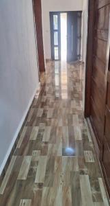 una stanza vuota con un pavimento in legno e un corridoio di Cuic apart a Cabinda
