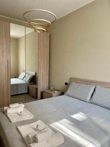 a bedroom with a bed with towels and a mirror at ERMAN HOUSE - Dimora del Doge in Dolo