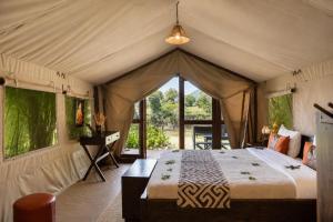 a bedroom with a bed in a tent at Exploreans Mara River Camp in Musiara Campsite