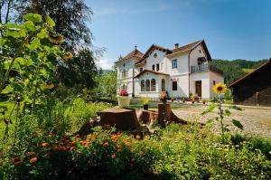 a large white house with a yard with flowers at Stary Dwór in Szczawnica