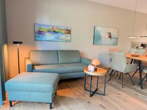 a living room with a couch and a table at Ferienwohnung Lütte Bleev am Dümmer See in Lembruch
