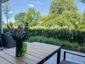 a vase of flowers sitting on a wooden table at Ferienwohnung Lütte Bleev am Dümmer See in Lembruch