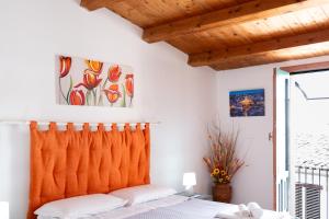 a bedroom with a bed with an orange curtain at A un Passo dal Centro in Modica +4 photos