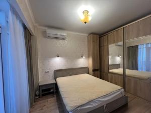 a small bedroom with a bed and a mirror at Guest Apart in Ozurgetʼi