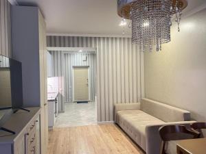 a living room with a couch and a chandelier at Guest Apart in Ozurgetʼi