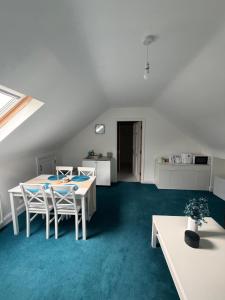 a room with a table and chairs and a kitchen at Cosy East Clare Apartment in Coolcoosaun