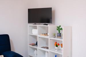 a white book shelf with a television on it at A un Passo dal Centro in Modica