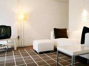 a living room with a white couch and a tv at Ferienwohnung in Hamburg West in Hamburg