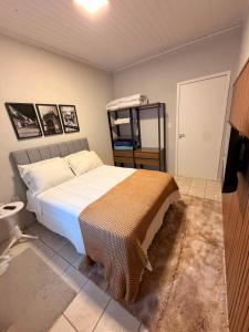 a bedroom with a bed and a shelf in it at Apart Centro 06 in Tubarão