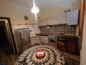 a kitchen with a table and a table and chairs at Casa Alby in Nulvi +22 photos