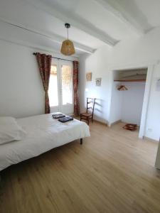 a bedroom with a bed and a large window at La Bouriotte Chambre d'hôtes Bouton D'Or in Labastide-Rouairoux